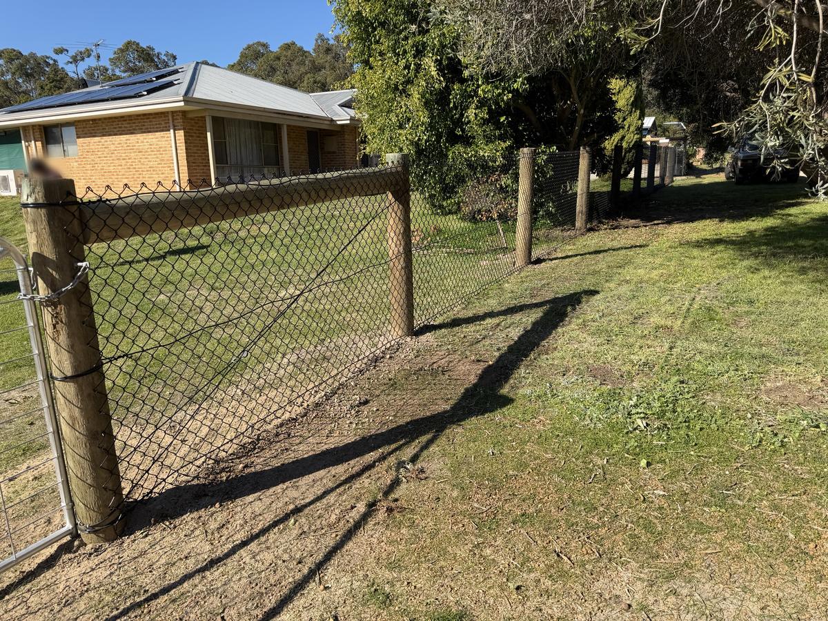 Black chainmesh fence with timber posts and galvanised gate