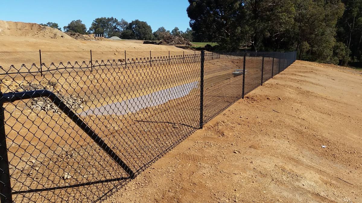 Black chainmesh fence on a subdivision