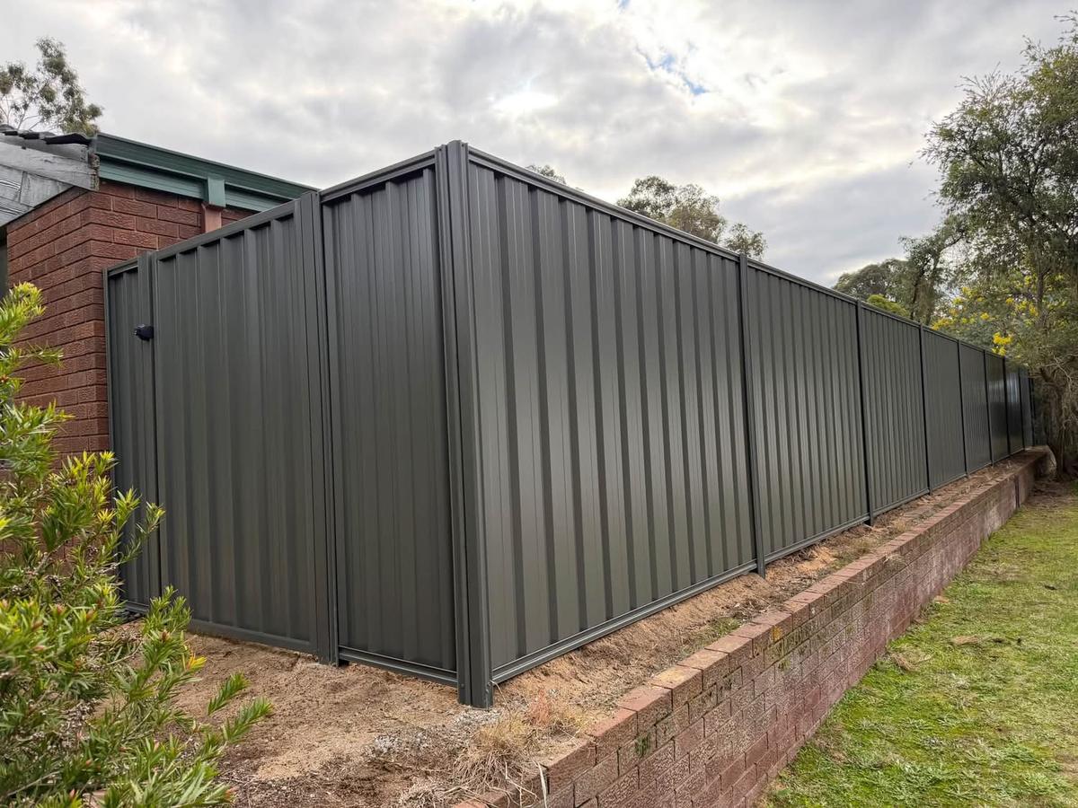 Colorbond fence and gate above a brick retaining edge