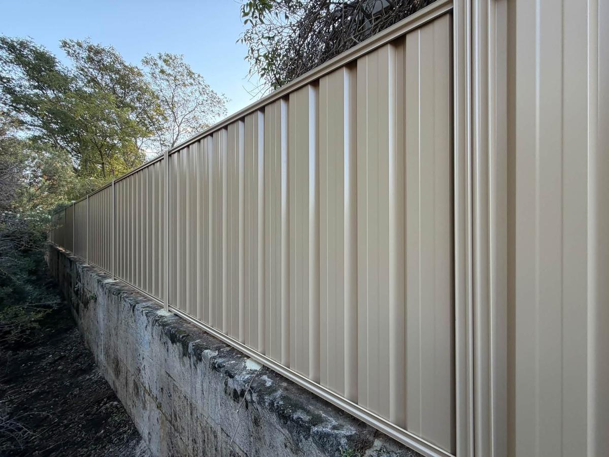Colorbond fence on top of a limestone retaining wall