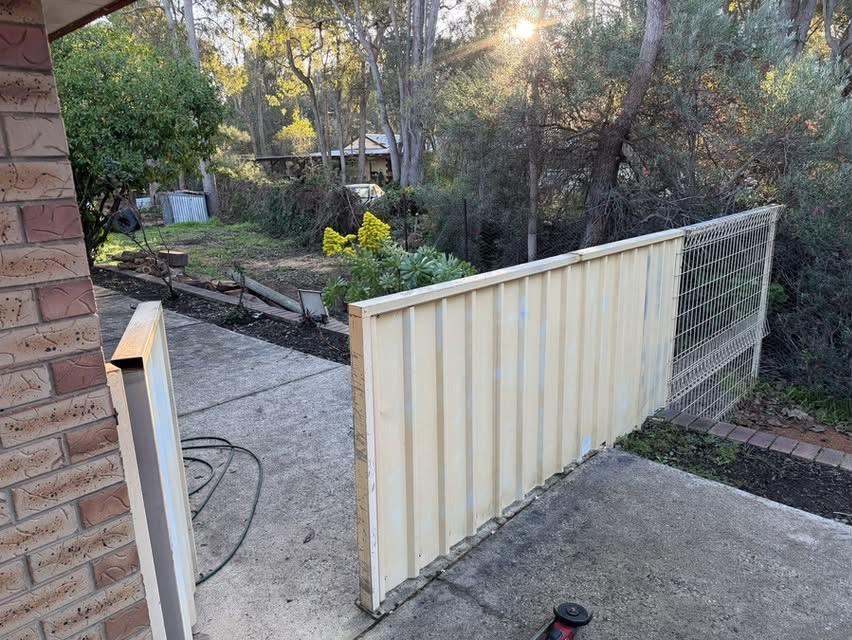 Old fence and mesh panel beside a house