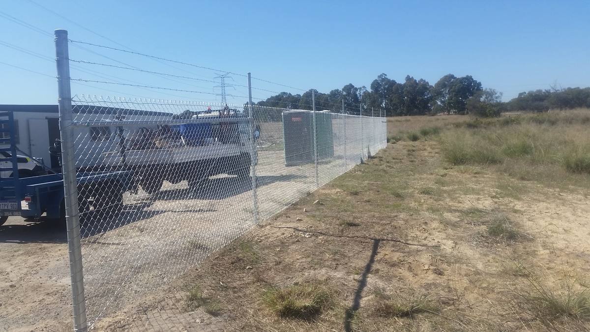 Galvanised chainmesh security fence with barbed wire